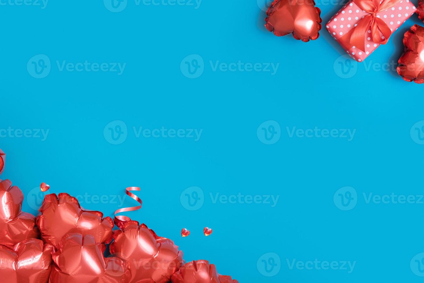Valentines Day background with copy space. Red heart shape balloons and gift box on turquoise background photo