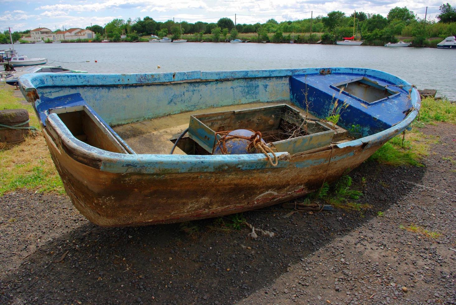 Old abandoned fishing rusty boat stranded on land photo