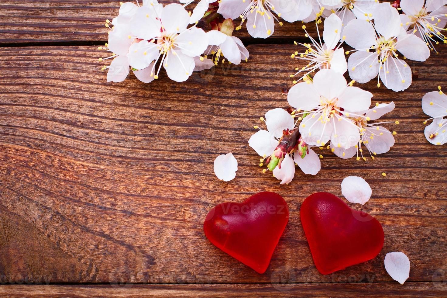 Flowering branch with white delicate flowers on wooden surface. photo