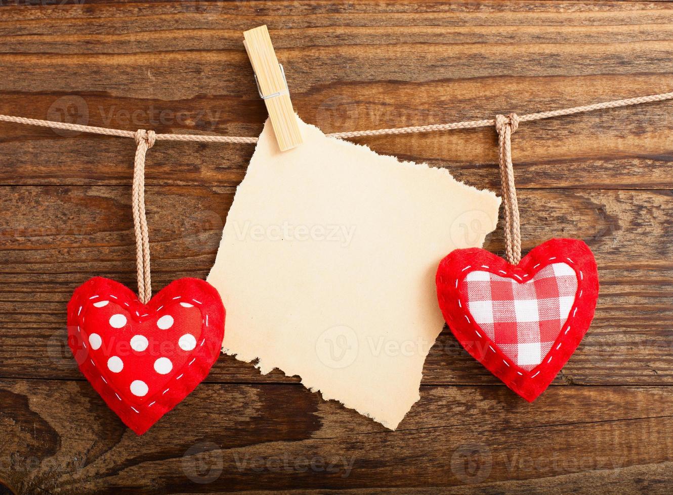 Blank sheet, a note, a torn sheet of paper and vintage red hearts hanging on garland. Valentines day concept photo