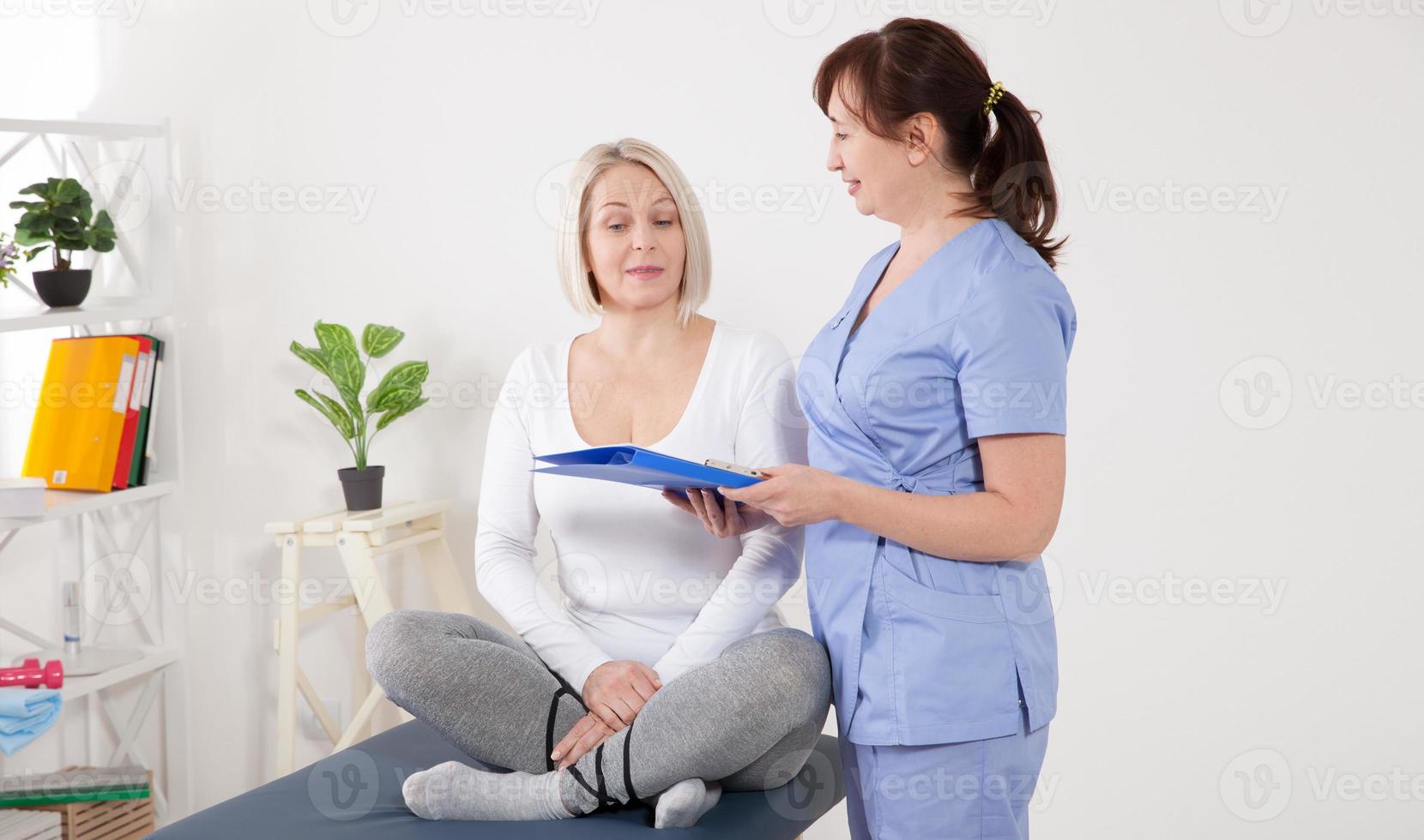 paciente femenina siendo tranquilizada por un médico en el hospital. foto