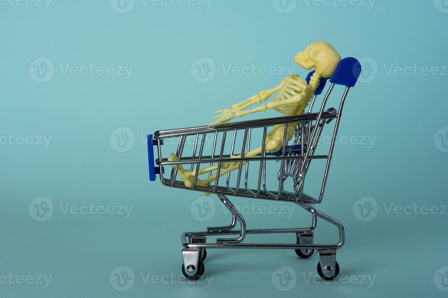 creative minimalist composition, a skeleton riding on a supermarket cart, turquoise background, a skull photo