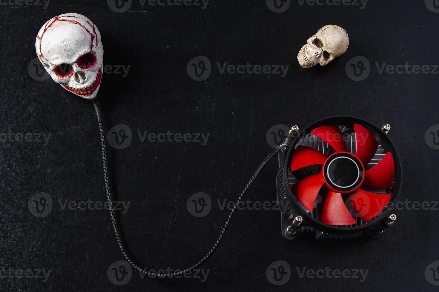 Creative composition, a computer cooler connected to a skull on a black background photo