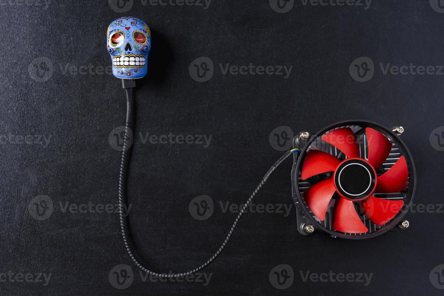 Creative composition, a computer cooler connected to a skull on a black background photo