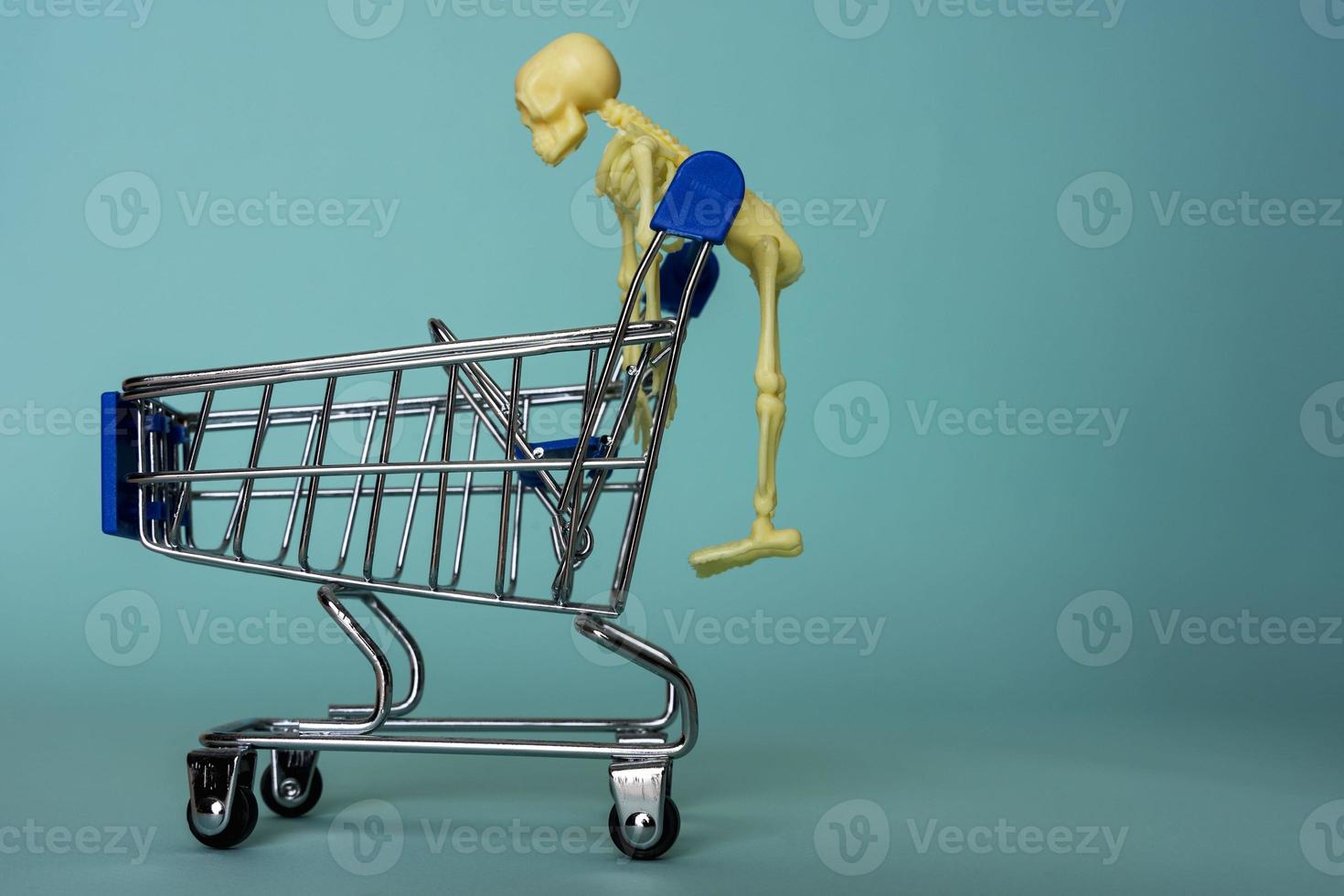 creative minimalist composition, a skeleton riding on a supermarket cart, turquoise background, a skull photo