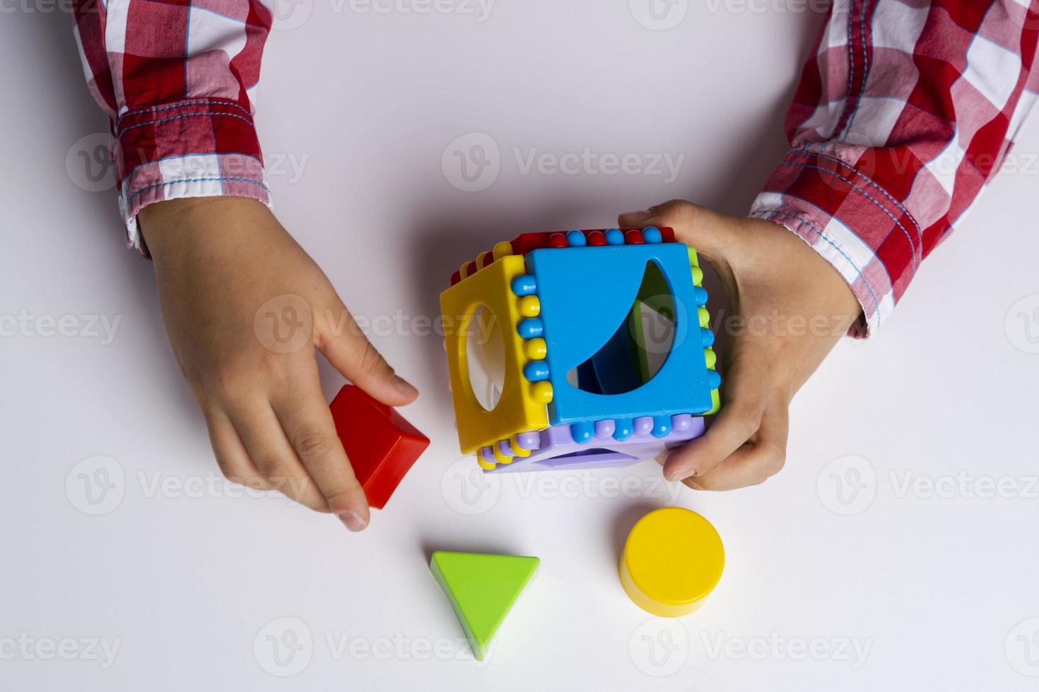 el niño recopila el constructor del clasificador de cubos. clasificador de cubos de rompecabezas, un concepto de desarrollo temprano. foto