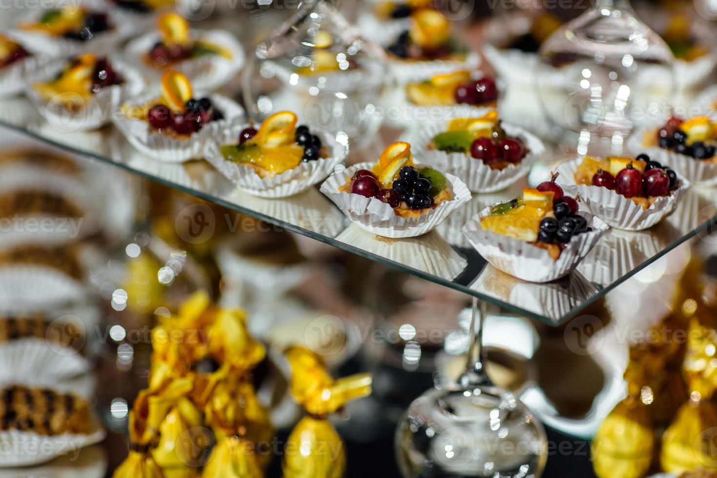 delicious candy bar at luxury wedding reception. exclusive expensive catering. table with modern desserts, cupcakes, sweets with fruits. baby or bridal shower. holiday celebration. selective focus. photo