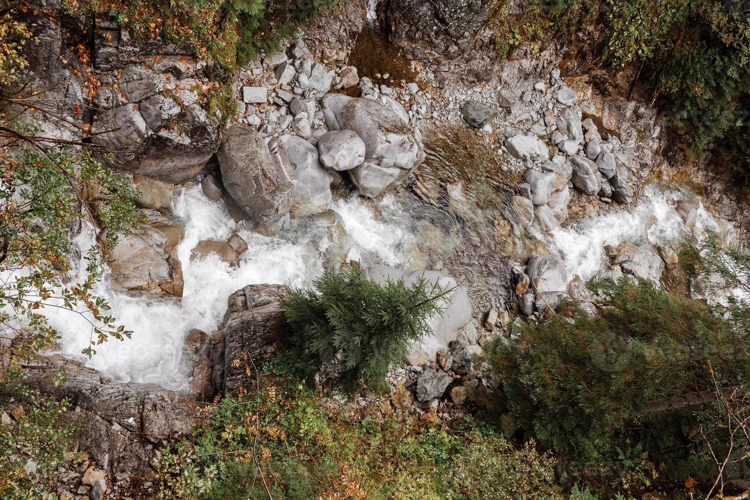 view from the mountain. A mountain river flows down from the mountains. trees background photo