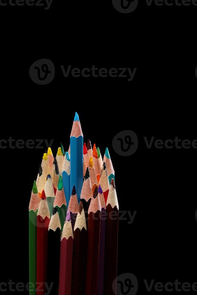 blue color pencil stands out among many color pencils on black background , selective focus photo