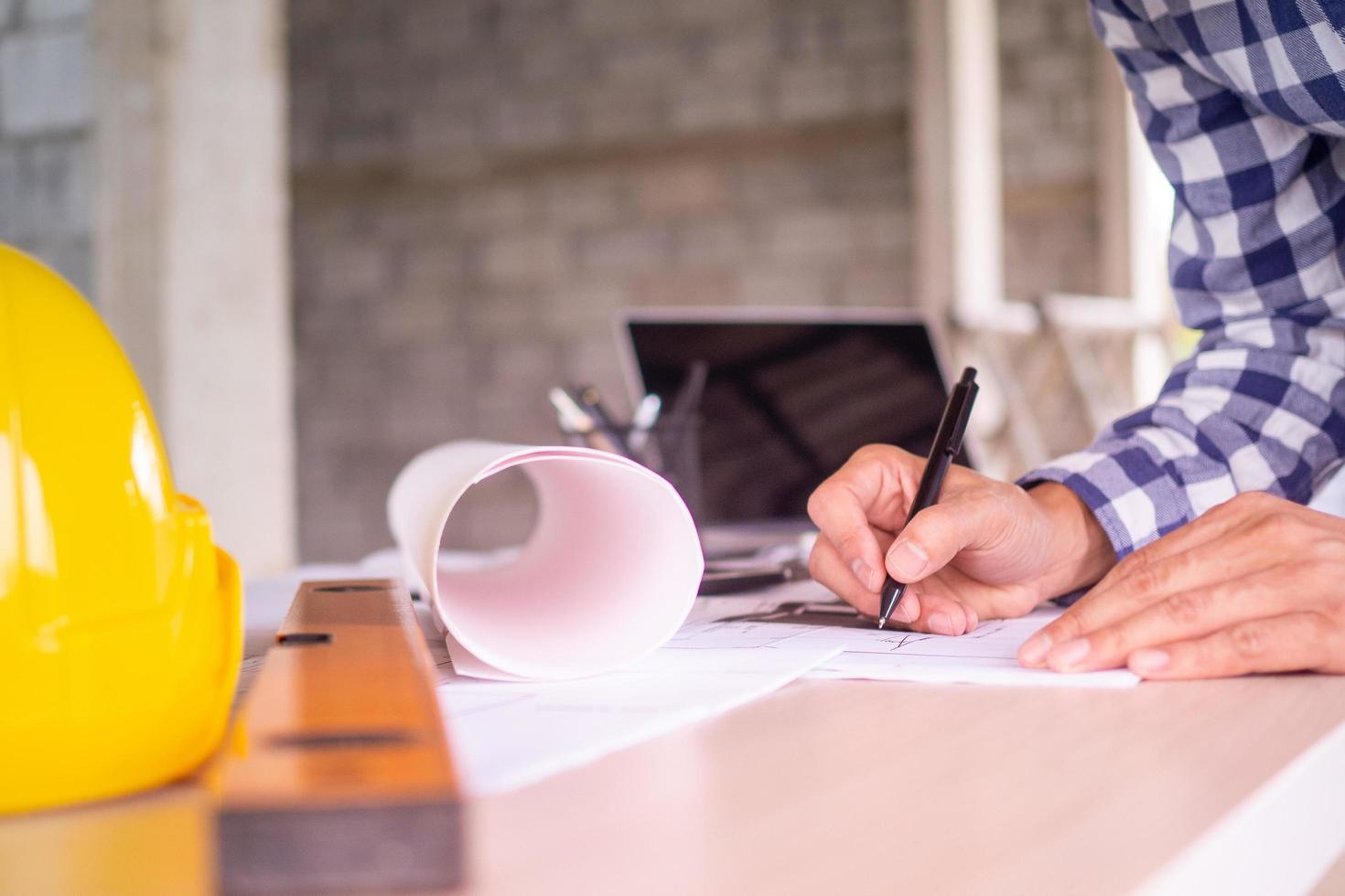 Man hand working of Architect sketching project on blueprint at site construction work. Concept of architect, engineer in the office desk construction project banner photo