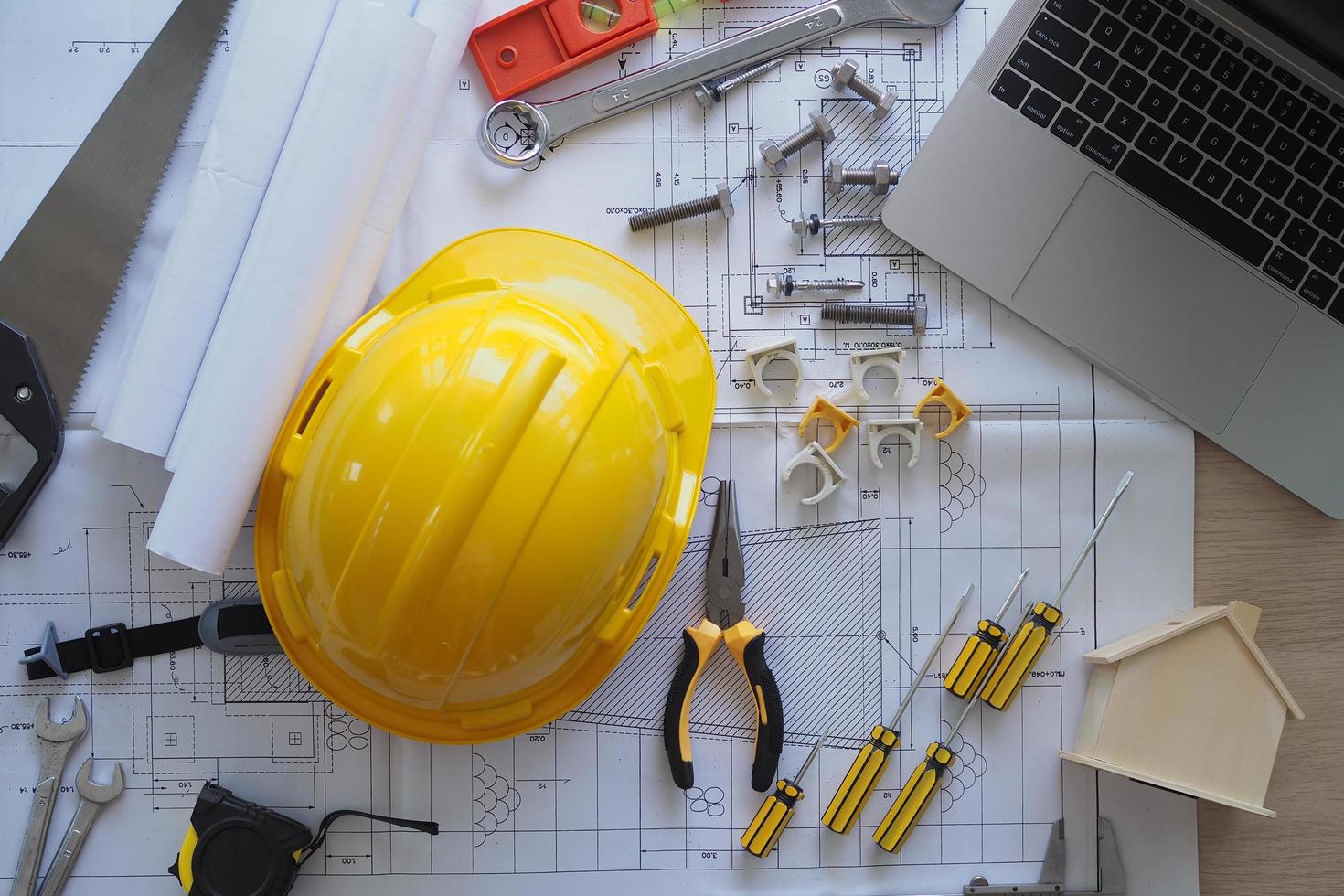 Contractor's desk and engineering team. There are blueprints, hard hats and various accessories. photo