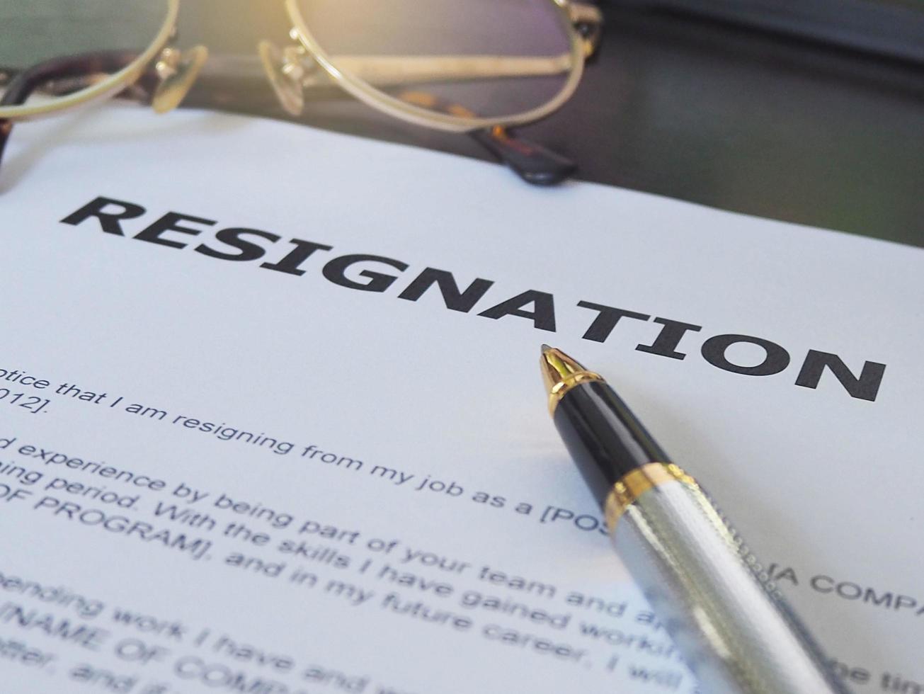 Resignation letter information with pen and glasses. photo