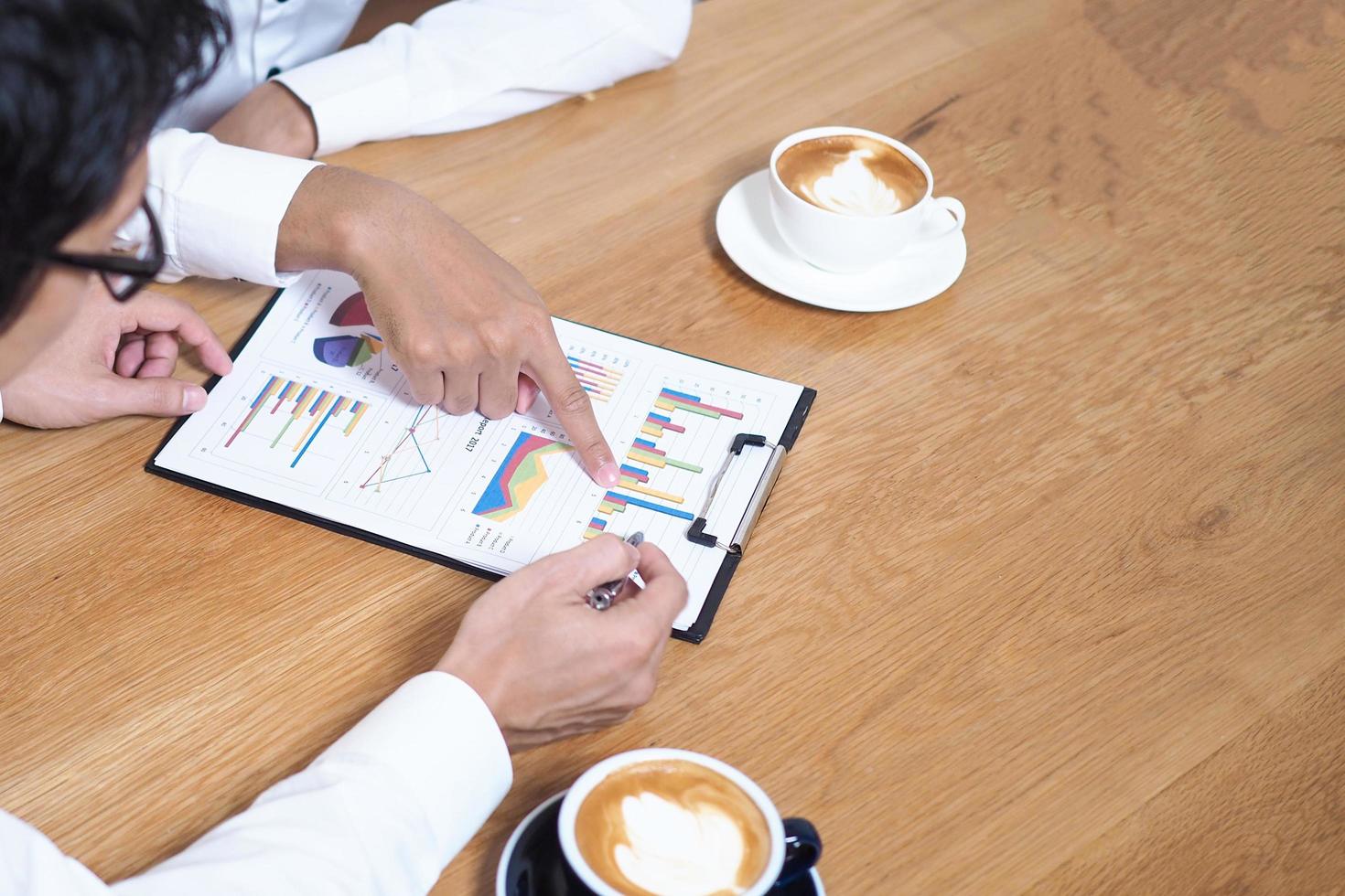 un hombre de negocios sentado con un consultor de negocios la tendencia del gráfico en el documento muestra la eficiencia de la empresa en conjunto para analizar y resolver los problemas que ocurrirán. foto