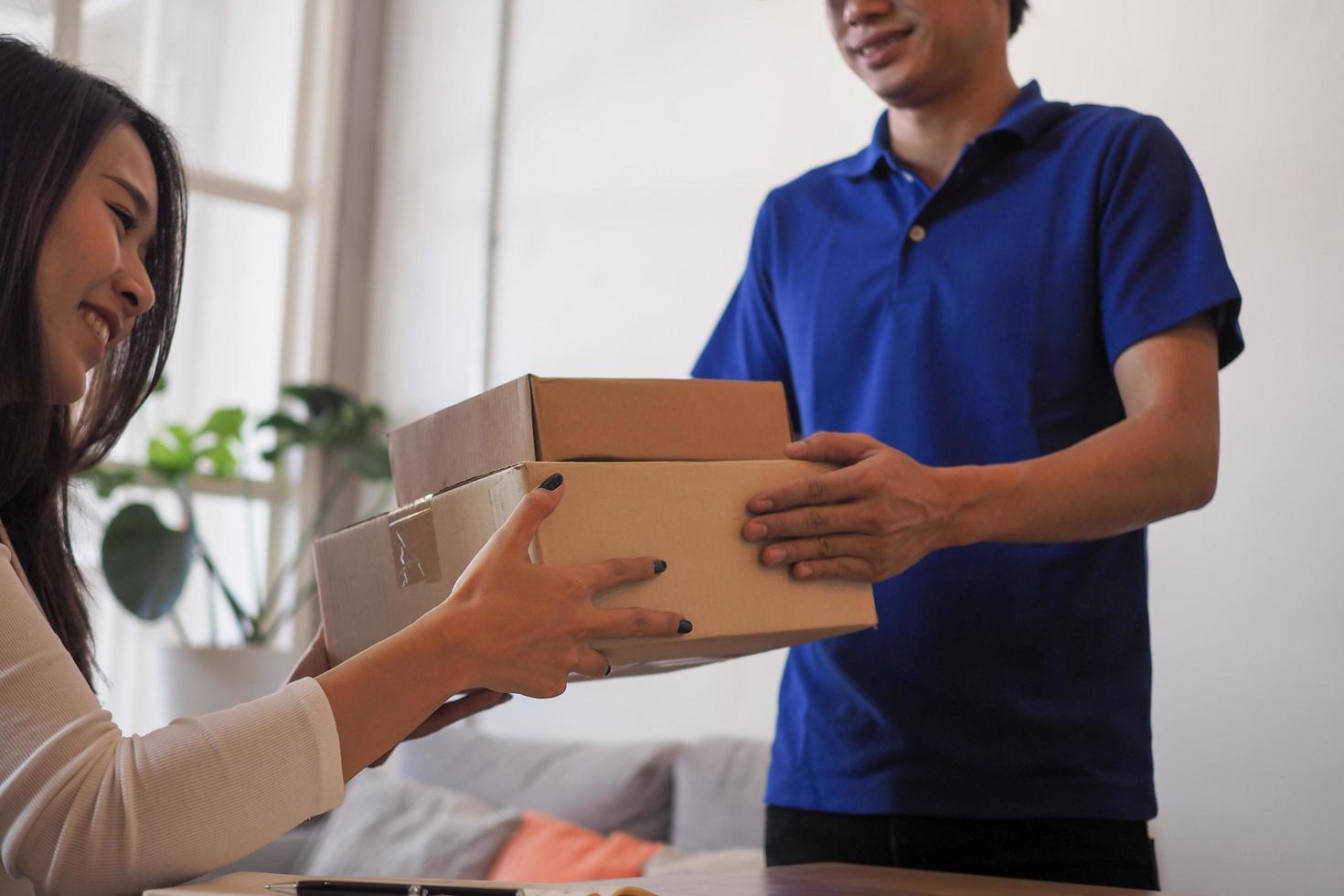 mujer aceptando productos de compras en línea del repartidor a domicilio. concepto de servicio, rápido y conveniente. quédate en casa y compra productos en línea. foto