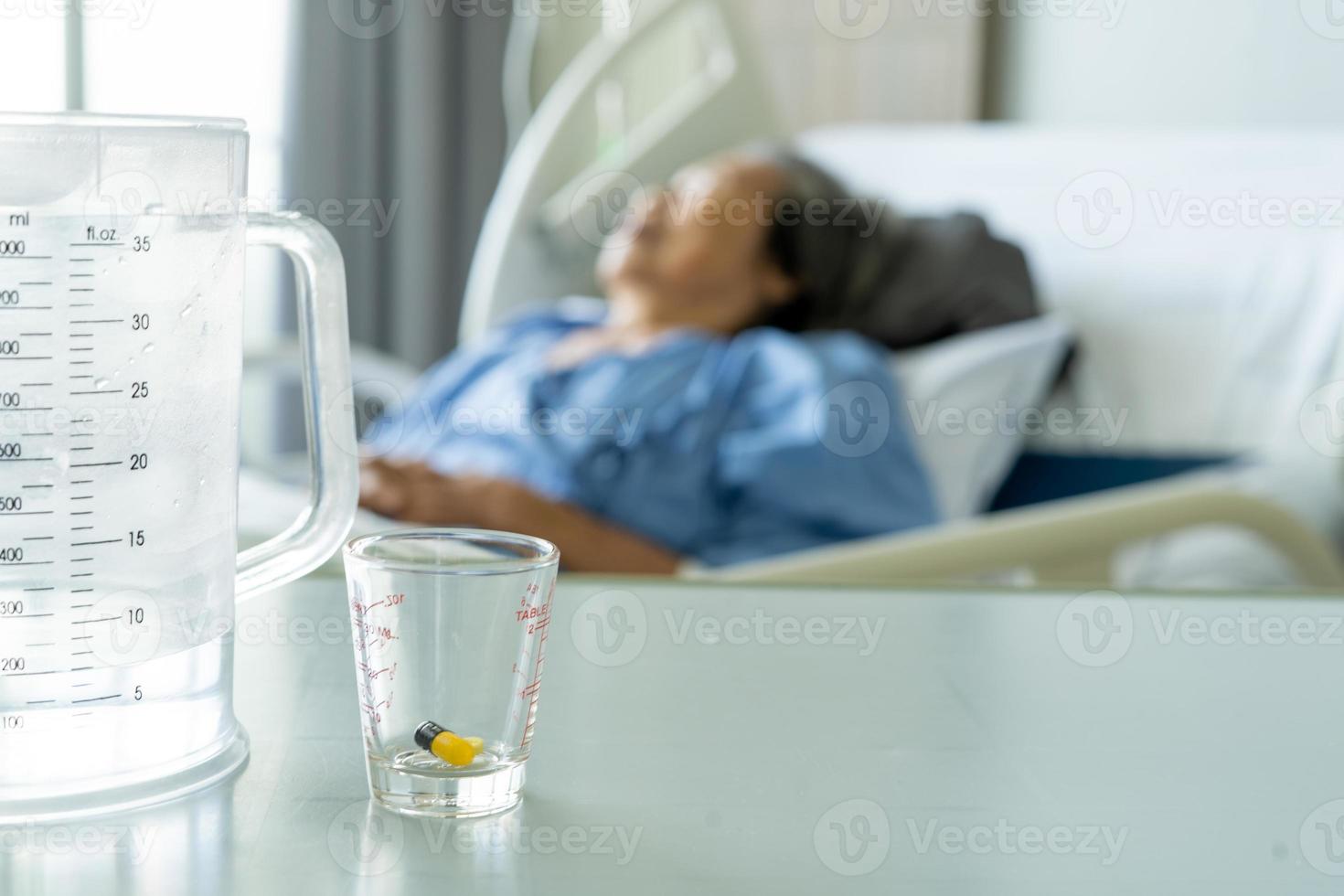 an elderly man's arm wearing a patient's uniform is lying in a saline bed in a hospital bed. illness, treatment and recovery concept photo