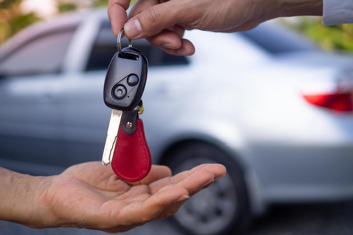 The car salesman and the key to the new owner. photo