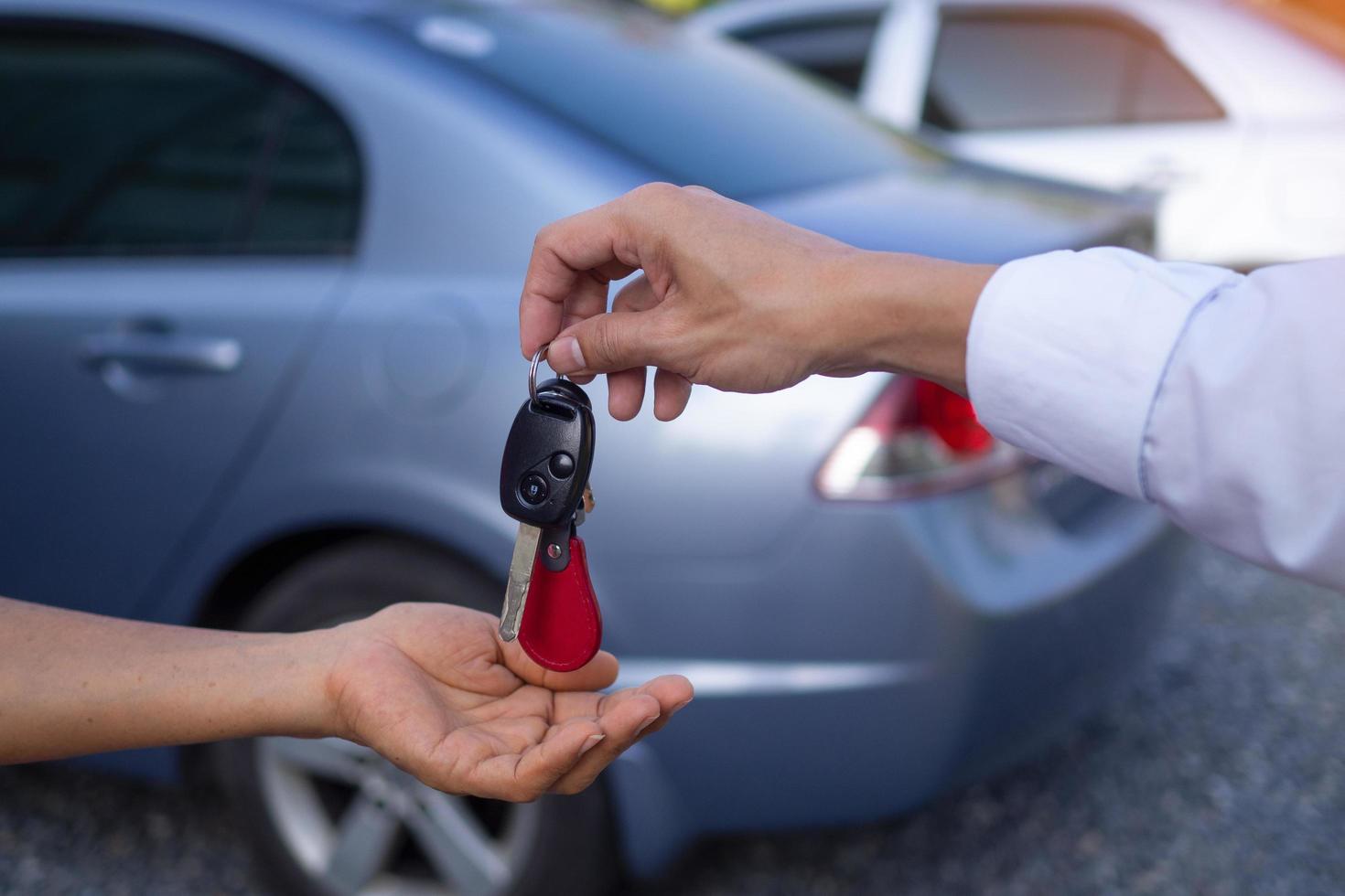 The car salesman and the key to the new owner. photo
