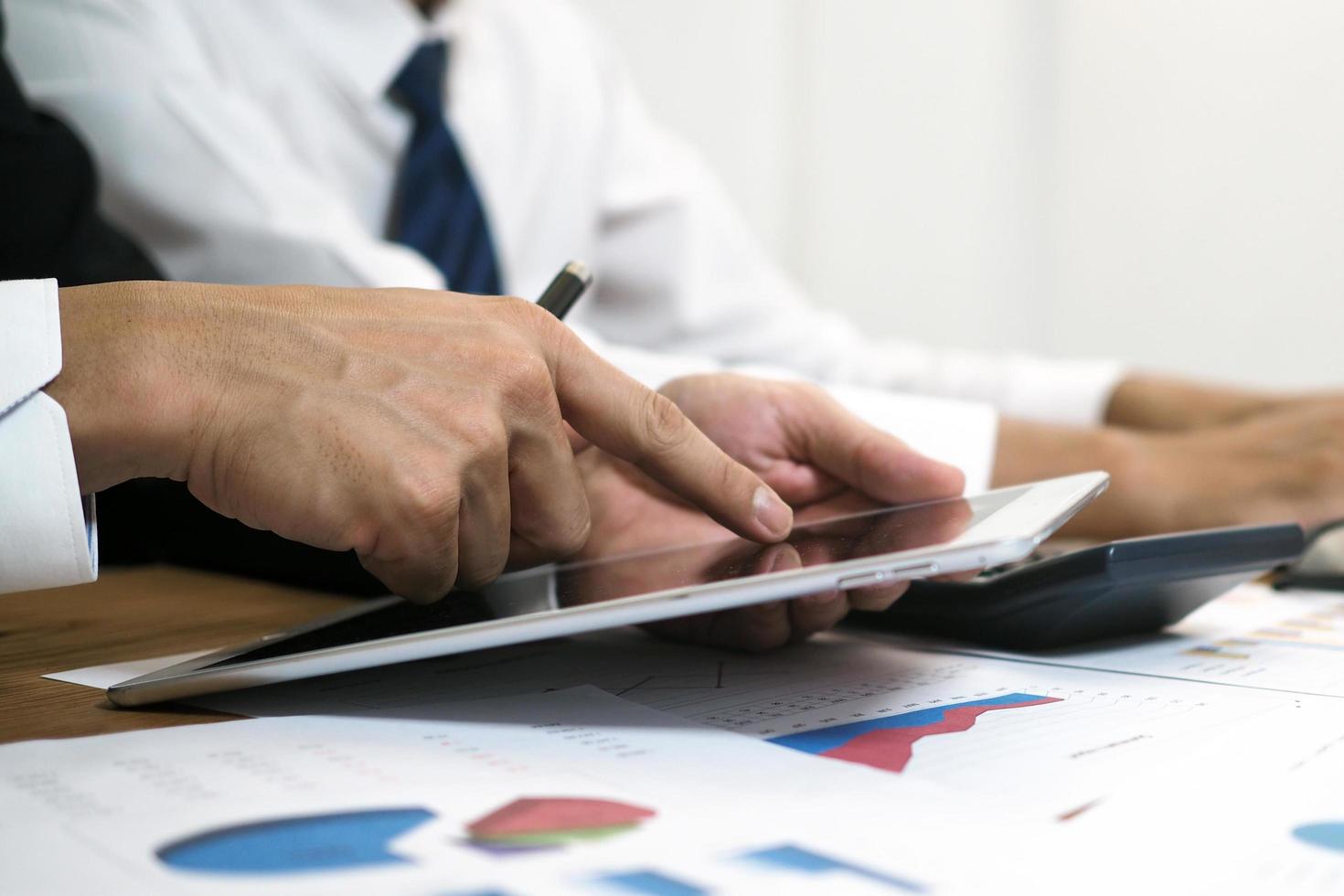 la gente de negocios usa el dedo para tocar la pantalla de la tableta para aprender y buscar información para trabajar. ver información en línea foto