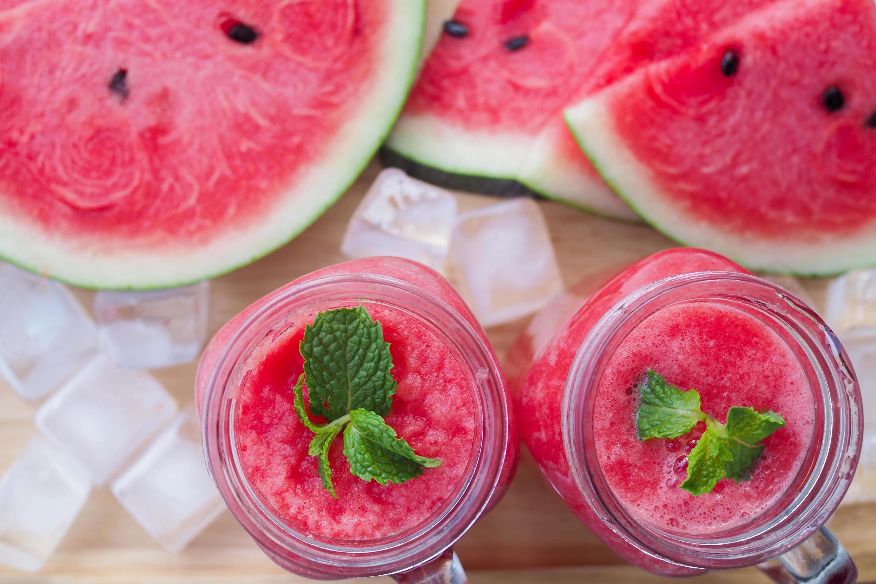 Fresh watermelon juice is in a glass and sliced watermelon on the plate