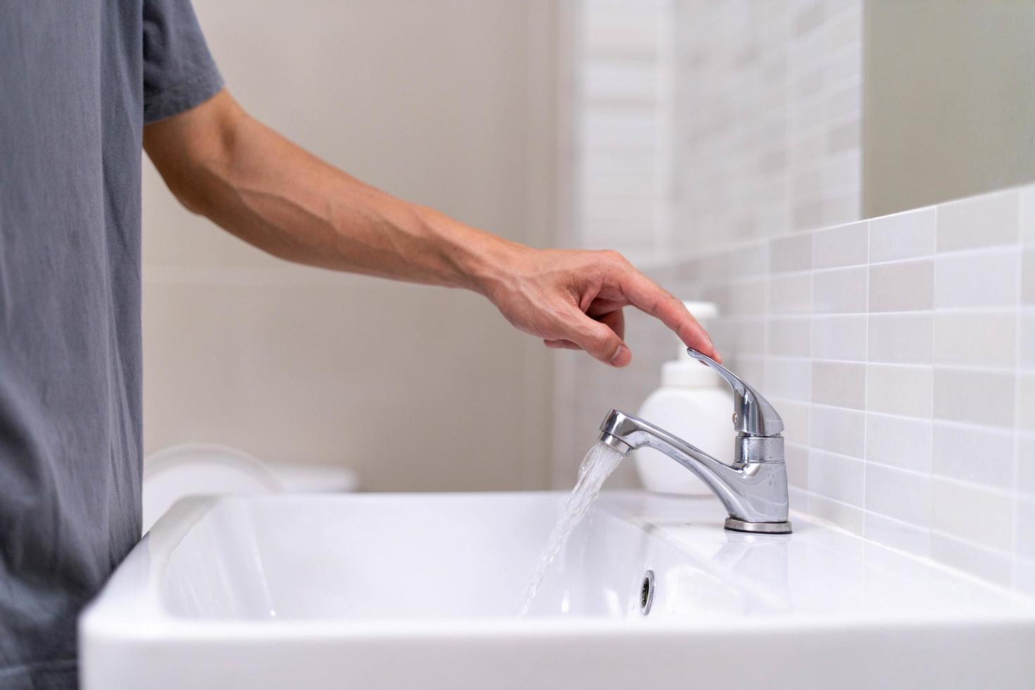 The faucet in the bathroom with running water. Man keeps turning off the water to save water energy and protect the environment. save water concept photo