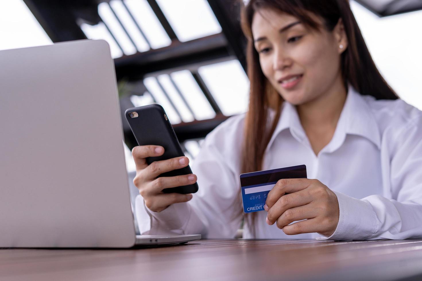 Close up female hands holding credit card and smartphone. Woman paying online,using banking service, entering information, Pay bills ,shopping concept. photo