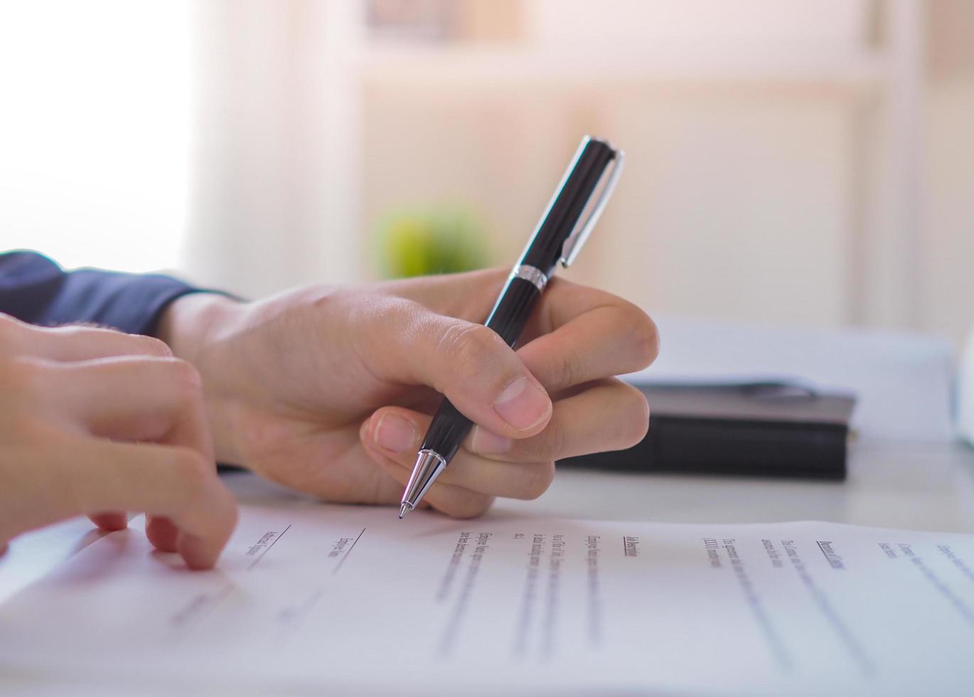 Young business women writing with left hand or signing a contract photo