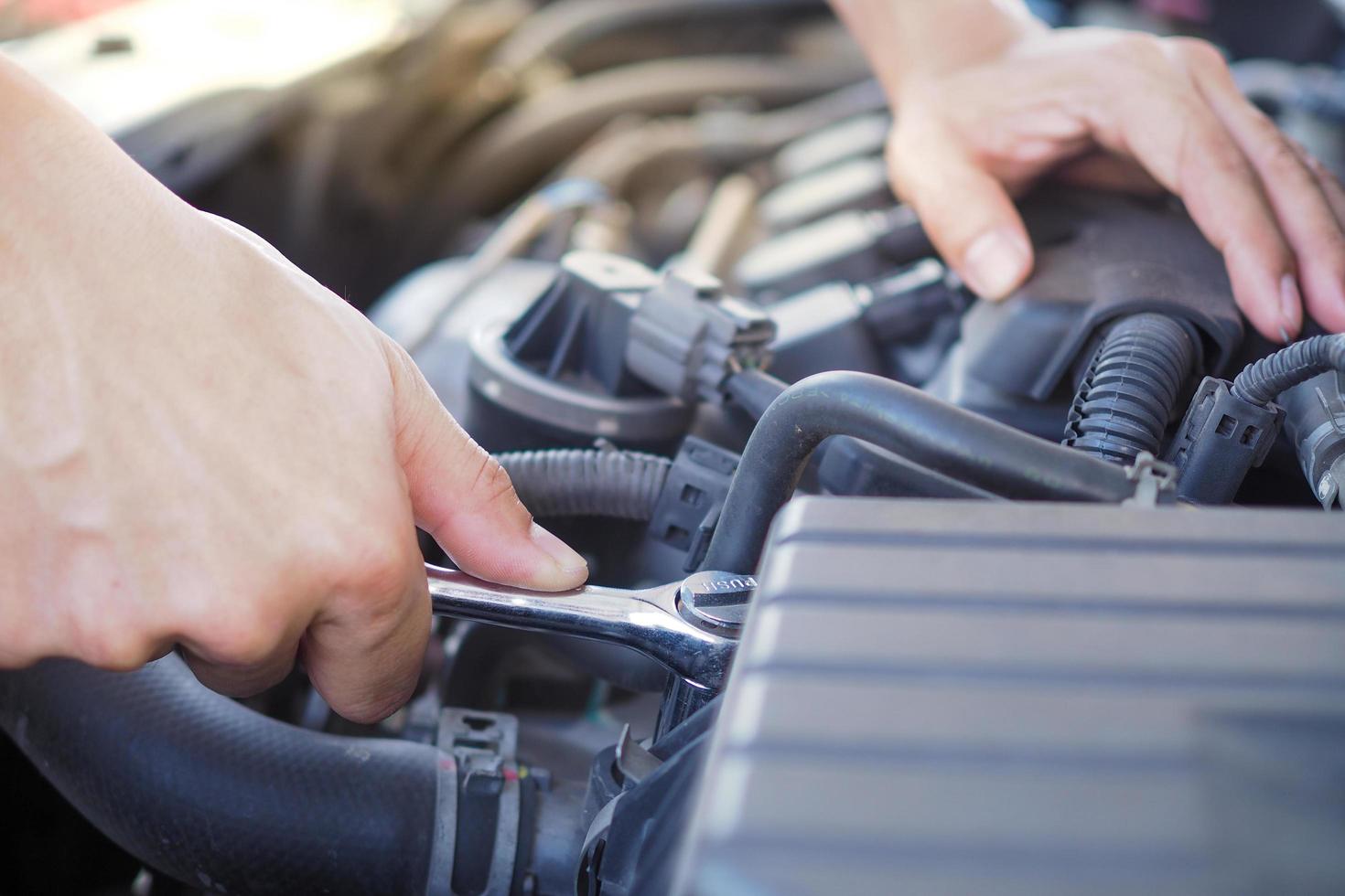 el ingeniero del motor está revisando y reparando el automóvil. foto