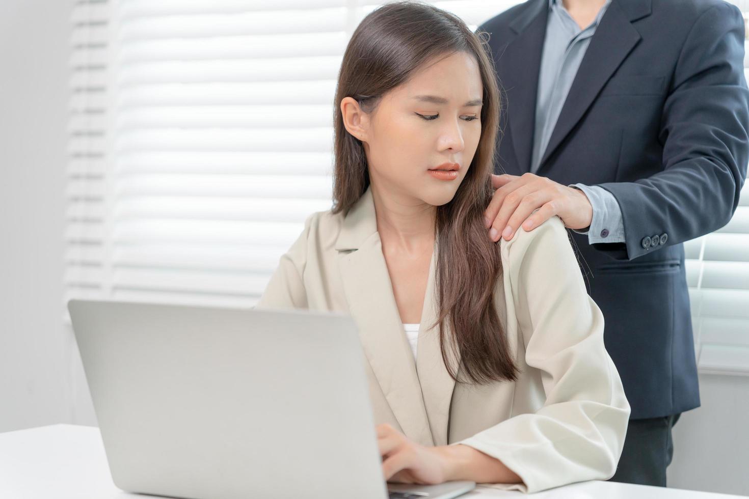 businessman sexually harassed a female colleague by touch her shoulder. Sexual harassment in office. Women feel anxious and stressed from being harassed. molest, assault, inappropriate, discrimination photo