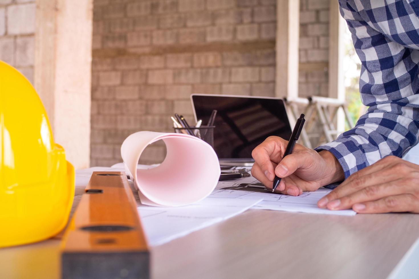 el ingeniero está redactando, escribe un proyecto, anótalo en papel para verificar y arreglar la casa antes de venderla al cliente. foto