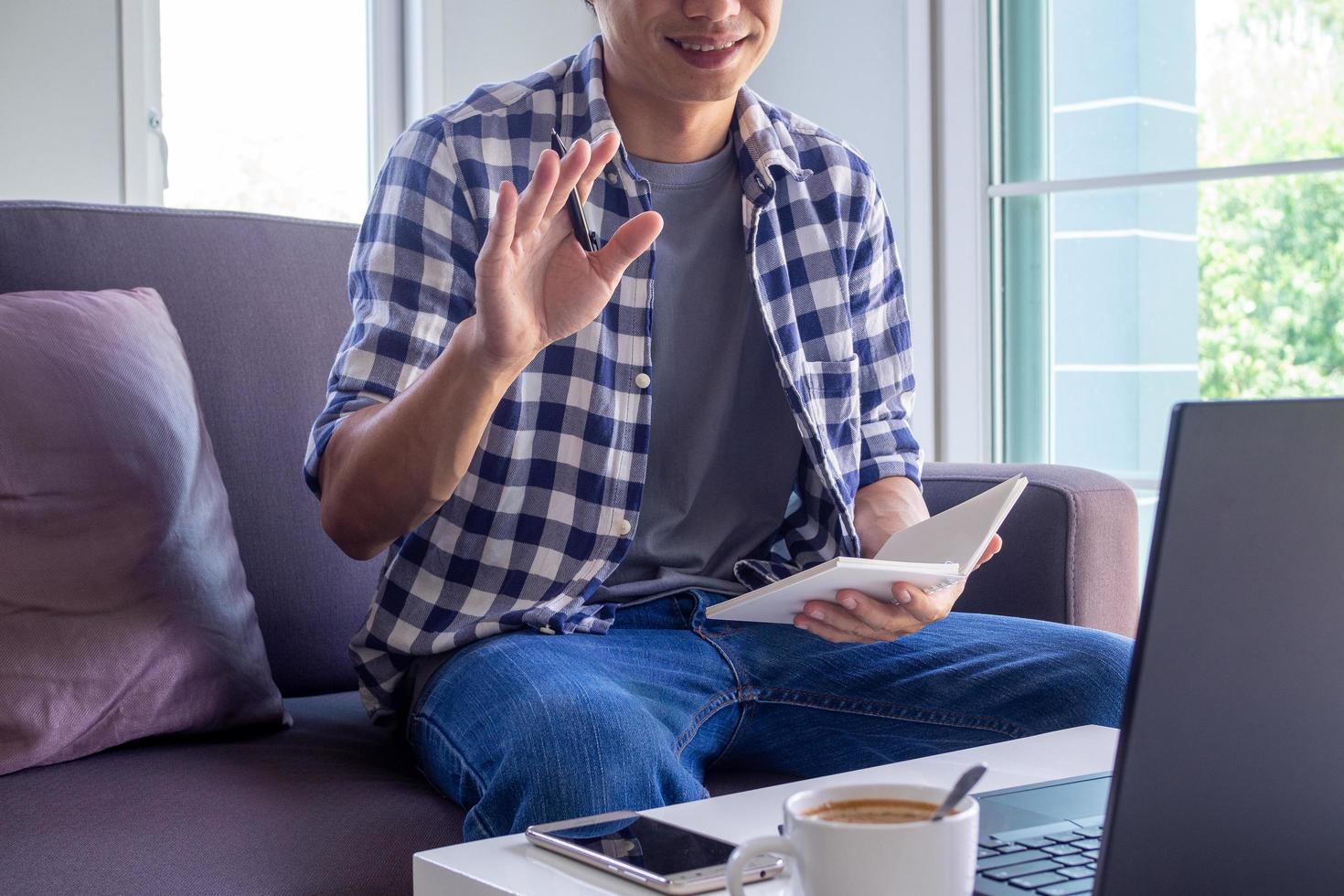 los hombres de negocios o los estudiantes están hablando de informes de ventas en videoconferencias. Los equipos asiáticos usan computadoras portátiles y tabletas, reuniones en línea, videollamadas, trabajo desde casa, trabajo remoto. foto