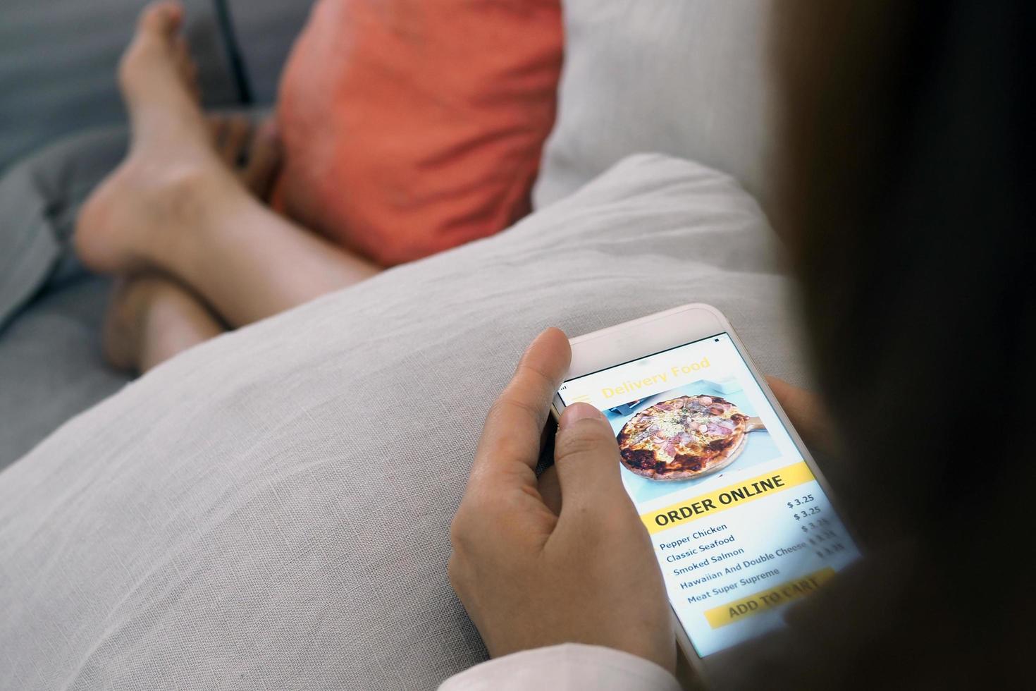 The woman's hand uses the phone to order food online photo