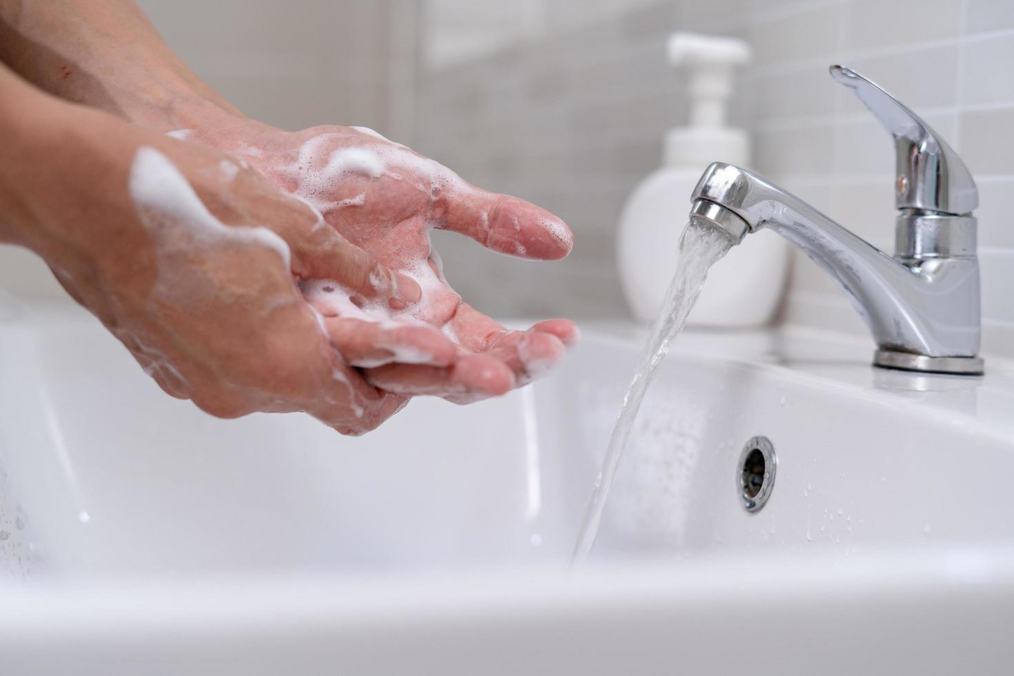 Person hands wash with soap bubbles and rinse with clean water to prevent and stop the spread of germs, virus or covid-19. Good health and good hygiene photo