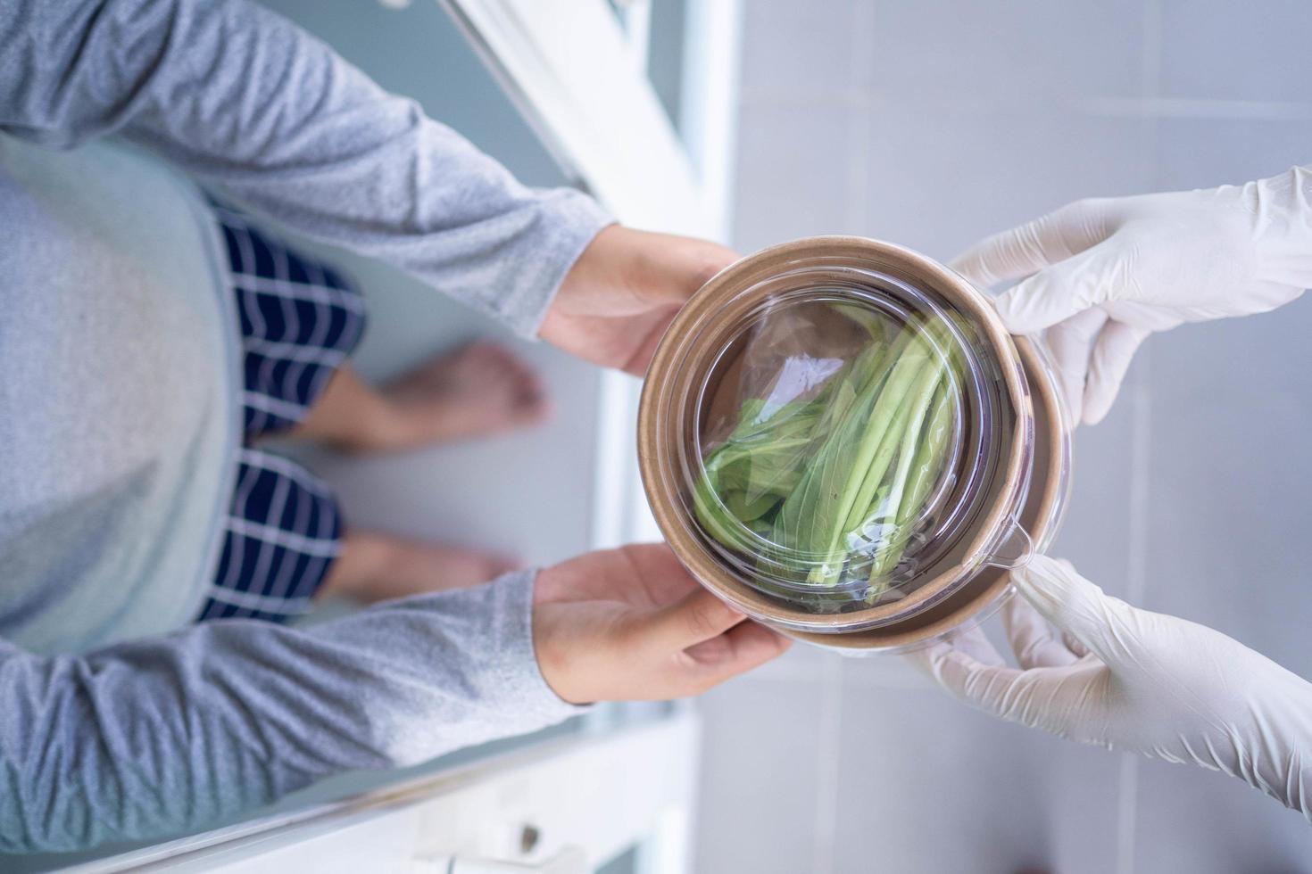 The shipper wears gloves, delivering food to the home of the online buyer. stay at home reduce the spread of the covid-19 virus. The sender has a service to deliver products or food quickly photo