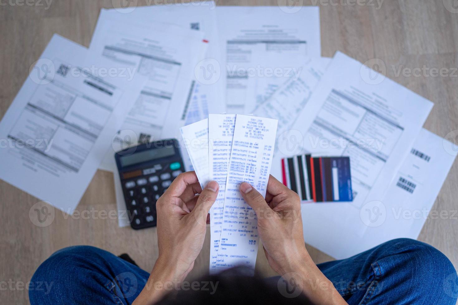 Men stress about a lot of credit card debt and bills on the floor. The housewife has trouble calculating monthly expenses and the budget is not enough to pay off the debt photo