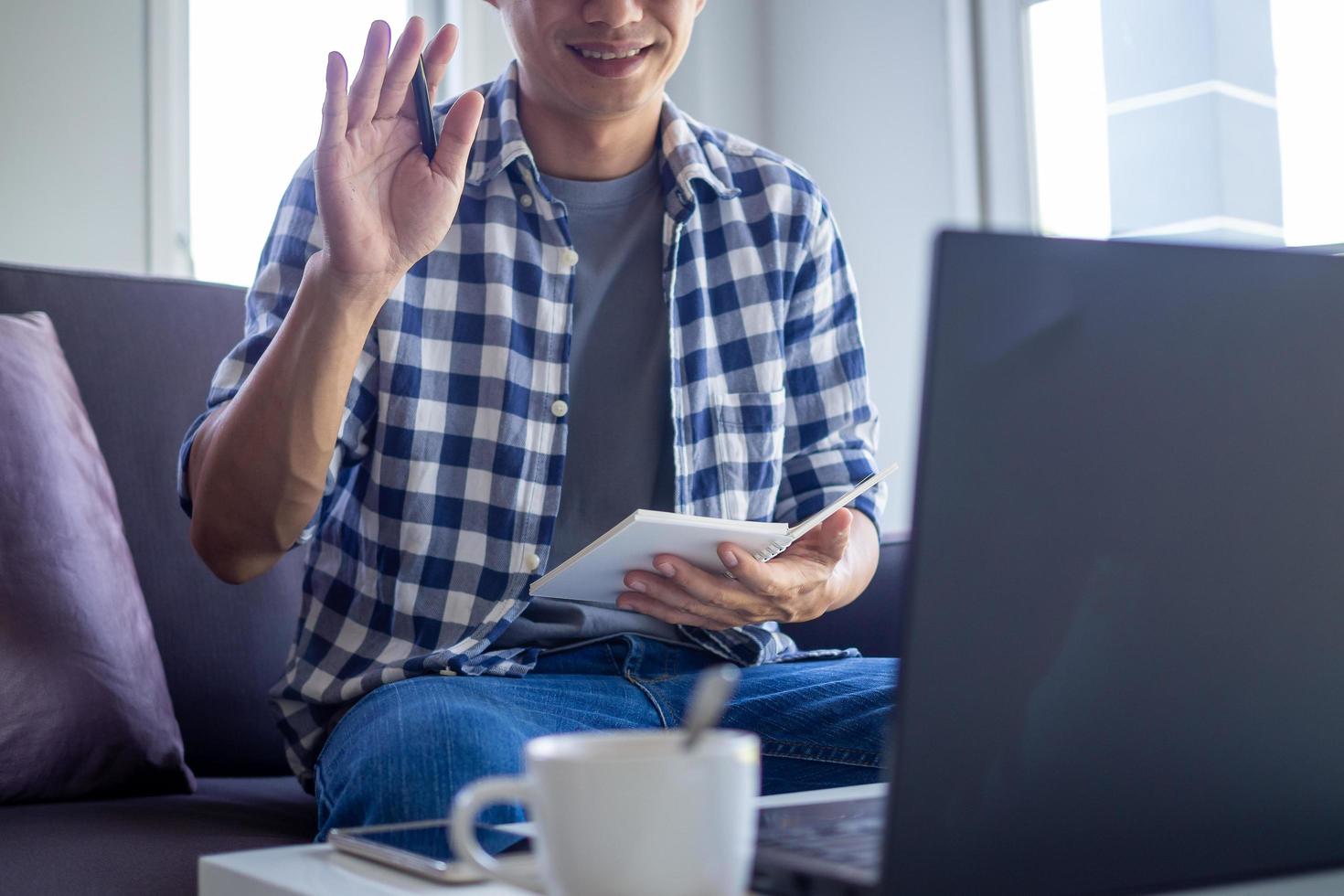 los hombres de negocios o los estudiantes están hablando de informes de ventas en videoconferencias. Los equipos asiáticos usan computadoras portátiles y tabletas, reuniones en línea, videollamadas, trabajo desde casa, trabajo remoto. foto