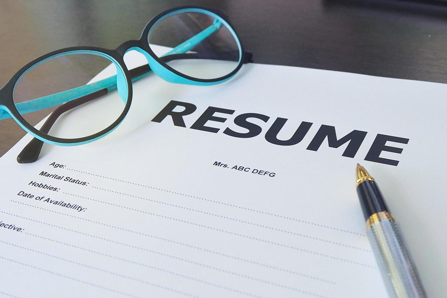 Job application form have pens and glasses. Close up of Resume photo