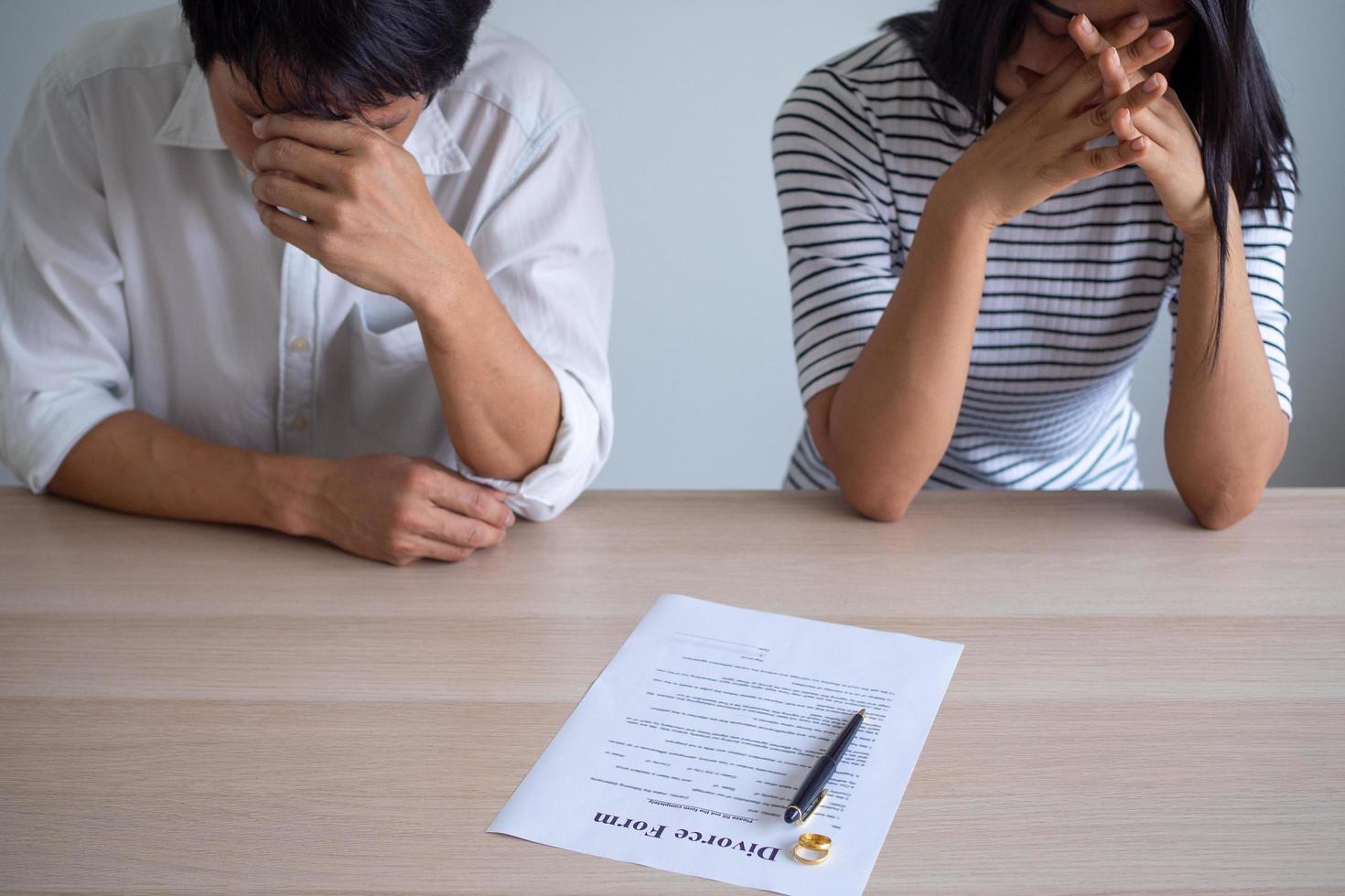 Couple is feeling stressed after agreeing to sign a divorce certificate. Concepts of lovers having family problems, divorce or quarrels or conflicts photo