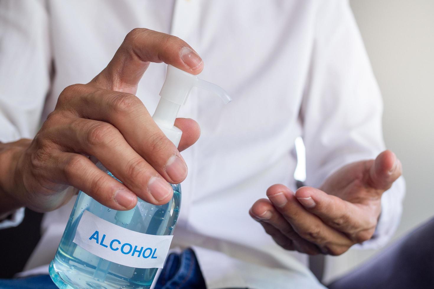 la mano del hombre presionando el gel para lavarse las manos y matar los gérmenes antes de entrar y salir o atrapar puertas. concepto de limpieza e higiene. prevenir covid-19 foto