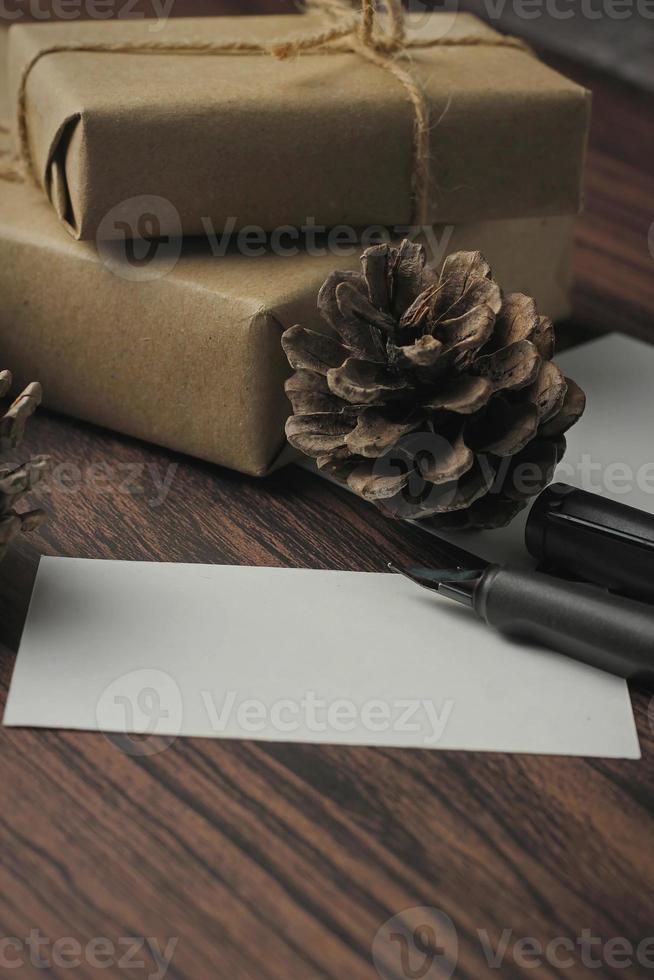 Gift boxes wrapped in recycled paper and gift cards, new year gift boxes Placed on a wooden table, a copyspace and a brown Christmas gift box. photo