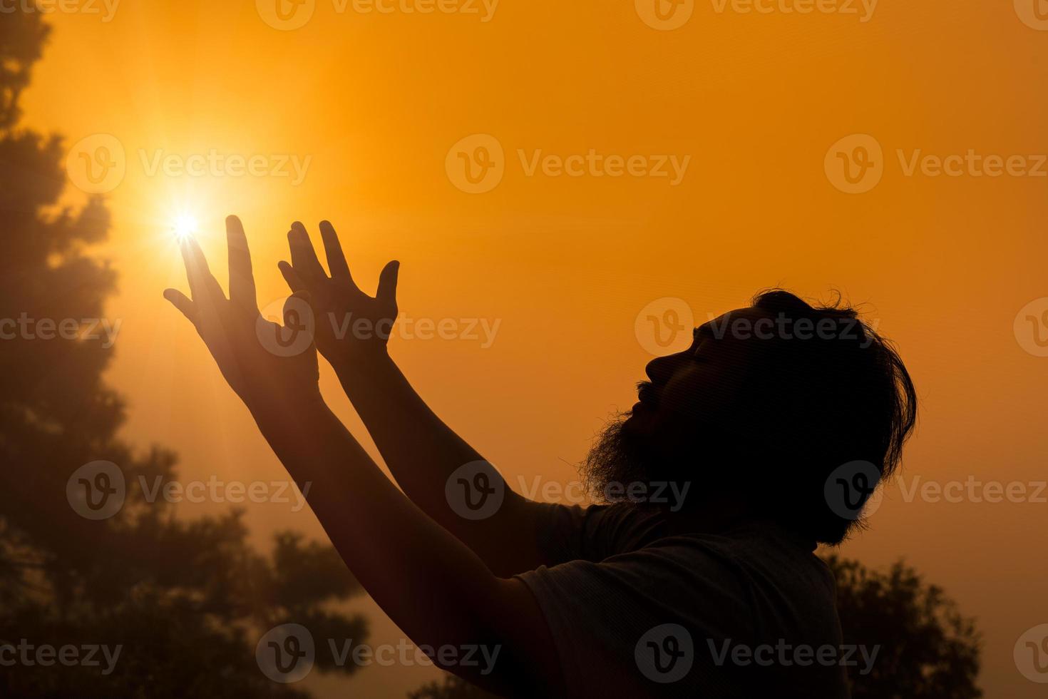 Worship with faith of christian concept. Spiritual prayer hands over sunshine with blurred beautiful sunrise sunset background. Preacher pray to God in morning with devotion. Christian man have hope. photo