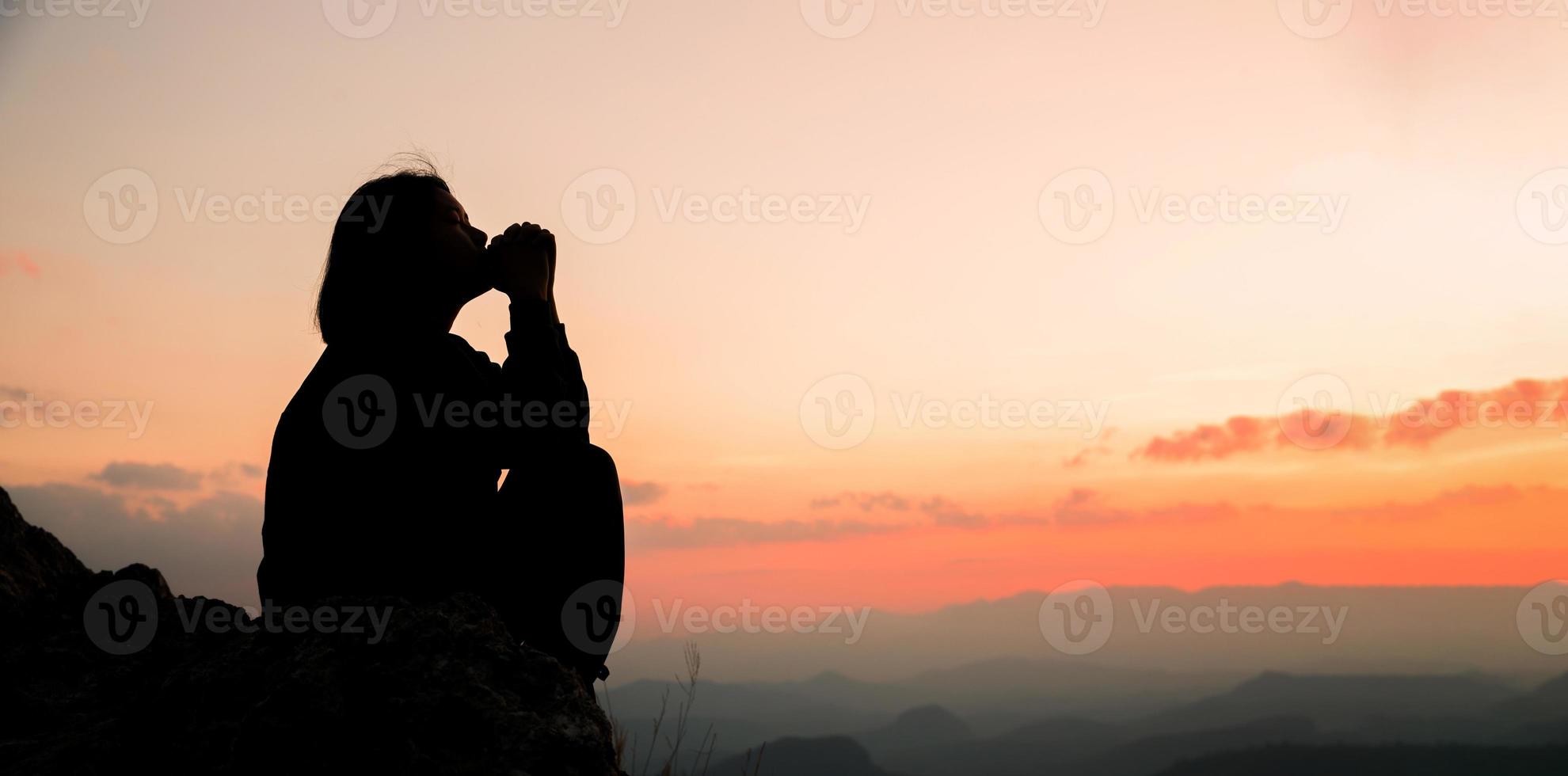 Banner of Faith christianity with christian worship concept. Spiritual prayer hands over sun shine with blurred beautiful sunset background. Woman praying to god with hopeful blessing against sunset. photo