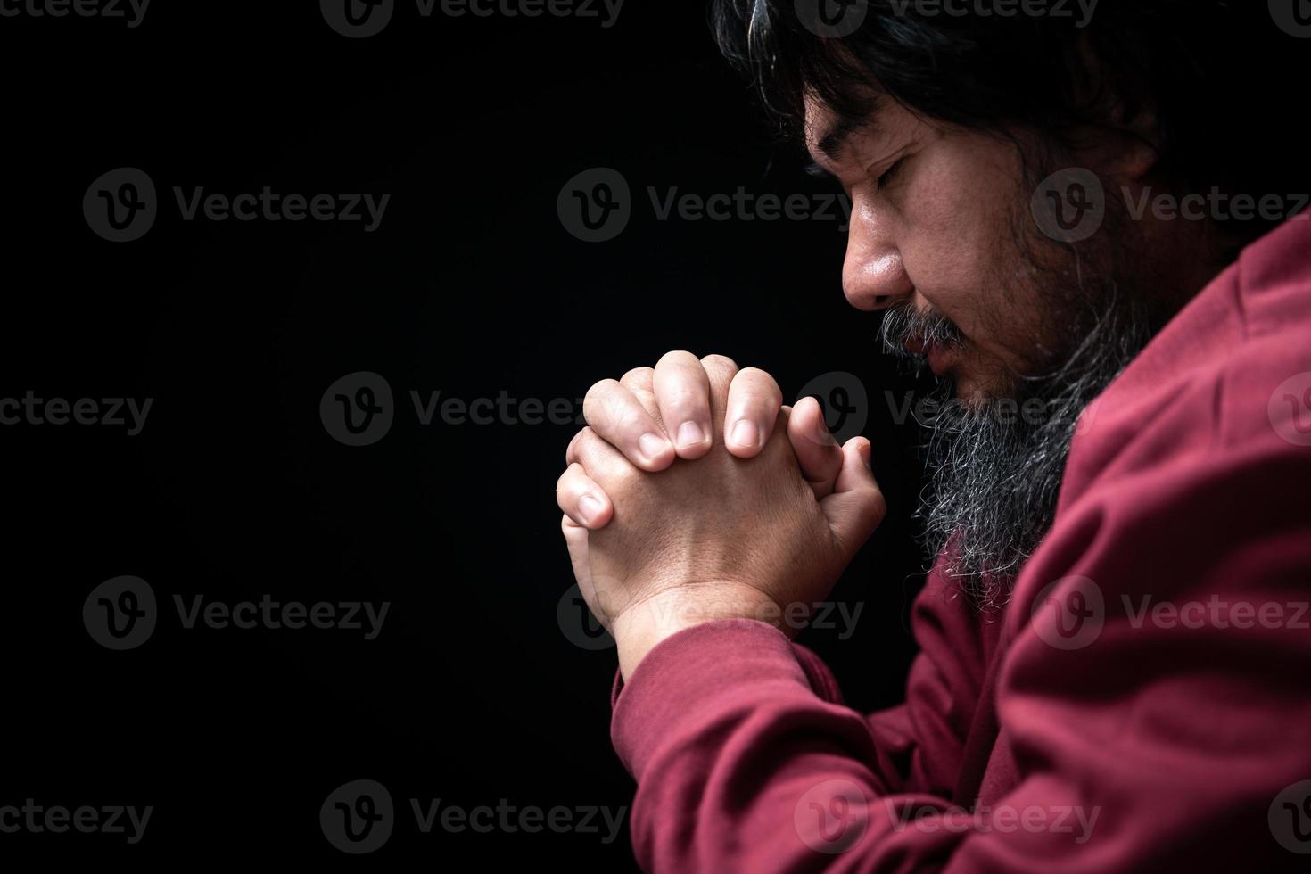 manos dobladas en oración en el concepto de la iglesia para la fe, la espiritualidad y la religión, el hombre rezando por la mañana. mano de hombre con dios rezando. Persona Los hombres cristianos que tienen fe en Jesús adoran en la oscuridad. foto