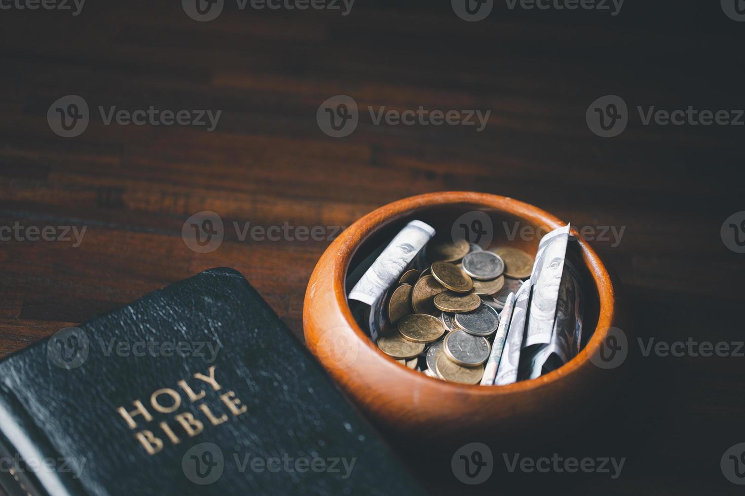 One tenth or tithe is basis on which Bible teaches us to give one tenth of first fruit to God. coins with Holy Bible. Biblical concept of Christian offering, generosity, and giving tithes in church. photo