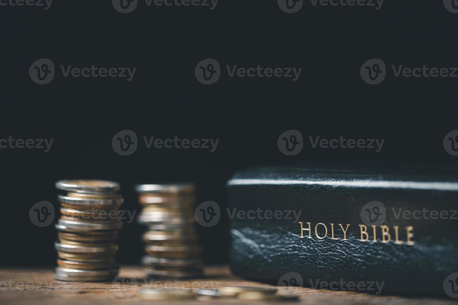 One tenth or tithe is basis on which Bible teaches us to give one tenth of first fruit to God. coins with Holy Bible. Biblical concept of Christian offering, generosity, and giving tithes in church. photo