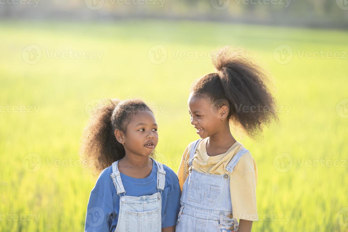 primer plano al aire libre de dos lindas hermanas negras sonriendo al atardecer. foto