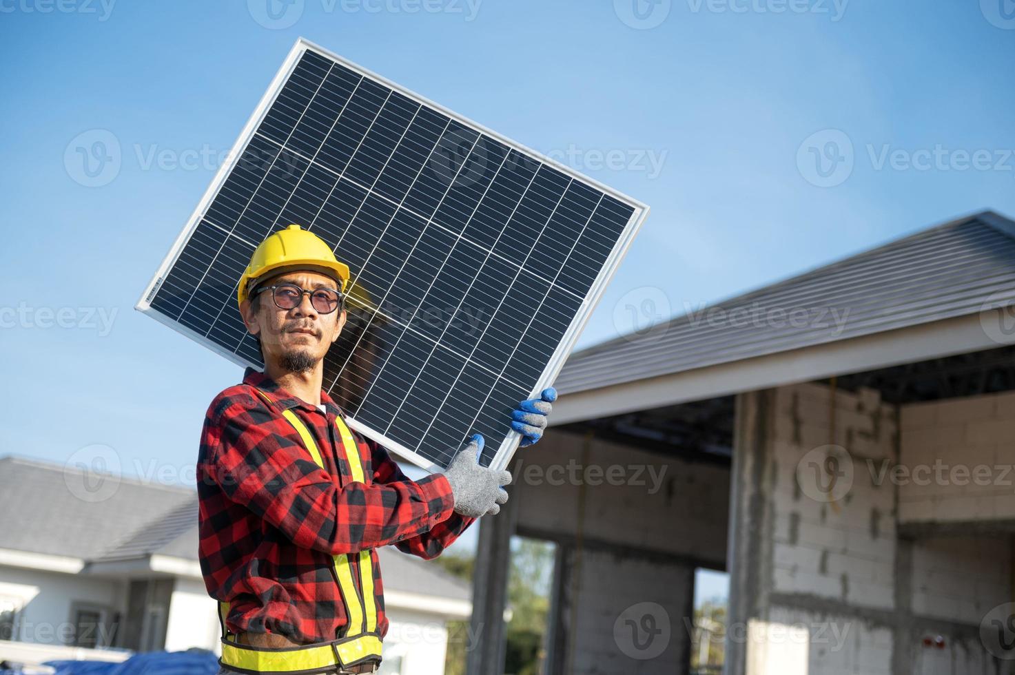 Technicians carrying solar panels ready to be installed on the roof of a housing estate energy-saving and cost-saving concept Own a small business installing solar panels. photo