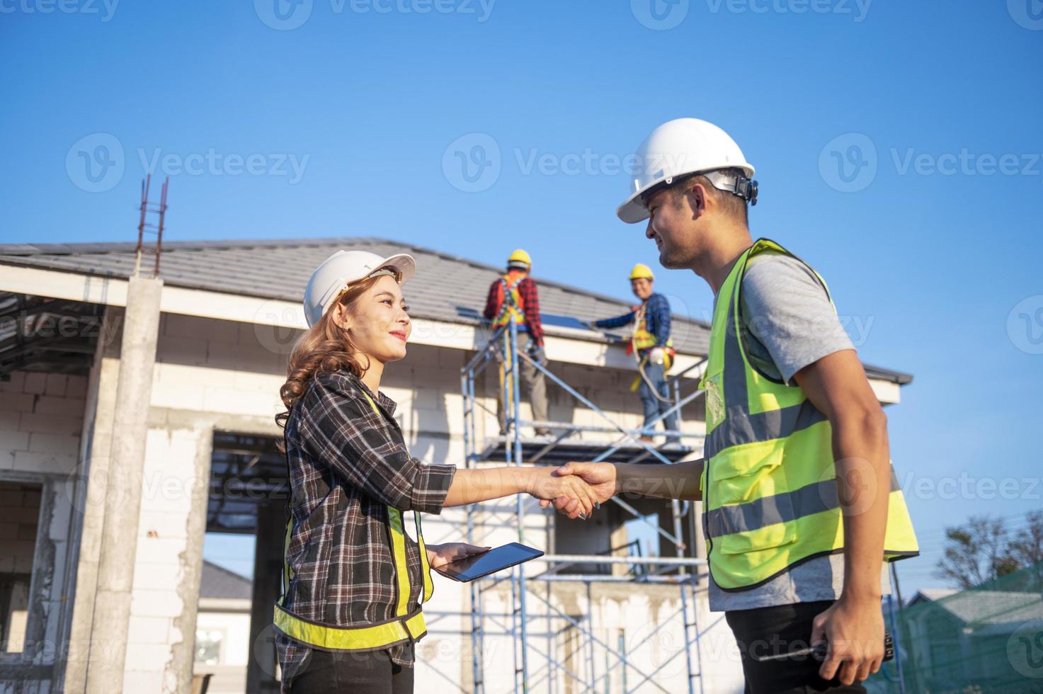 el inspector de construcción y la arquitecta hablan con el ingeniero jefe de asia sobre la instalación de paneles solares en un proyecto de construcción. Visite el sitio de construcción para instalar paneles solares. foto