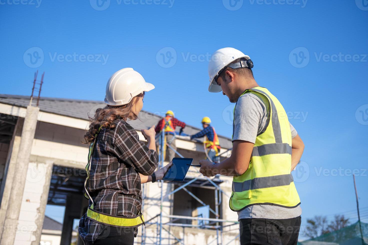 Construction inspector and female architect discuss with chief engineer Asia about installing solar panels on a construction project. Visit the construction site to install solar panels. photo