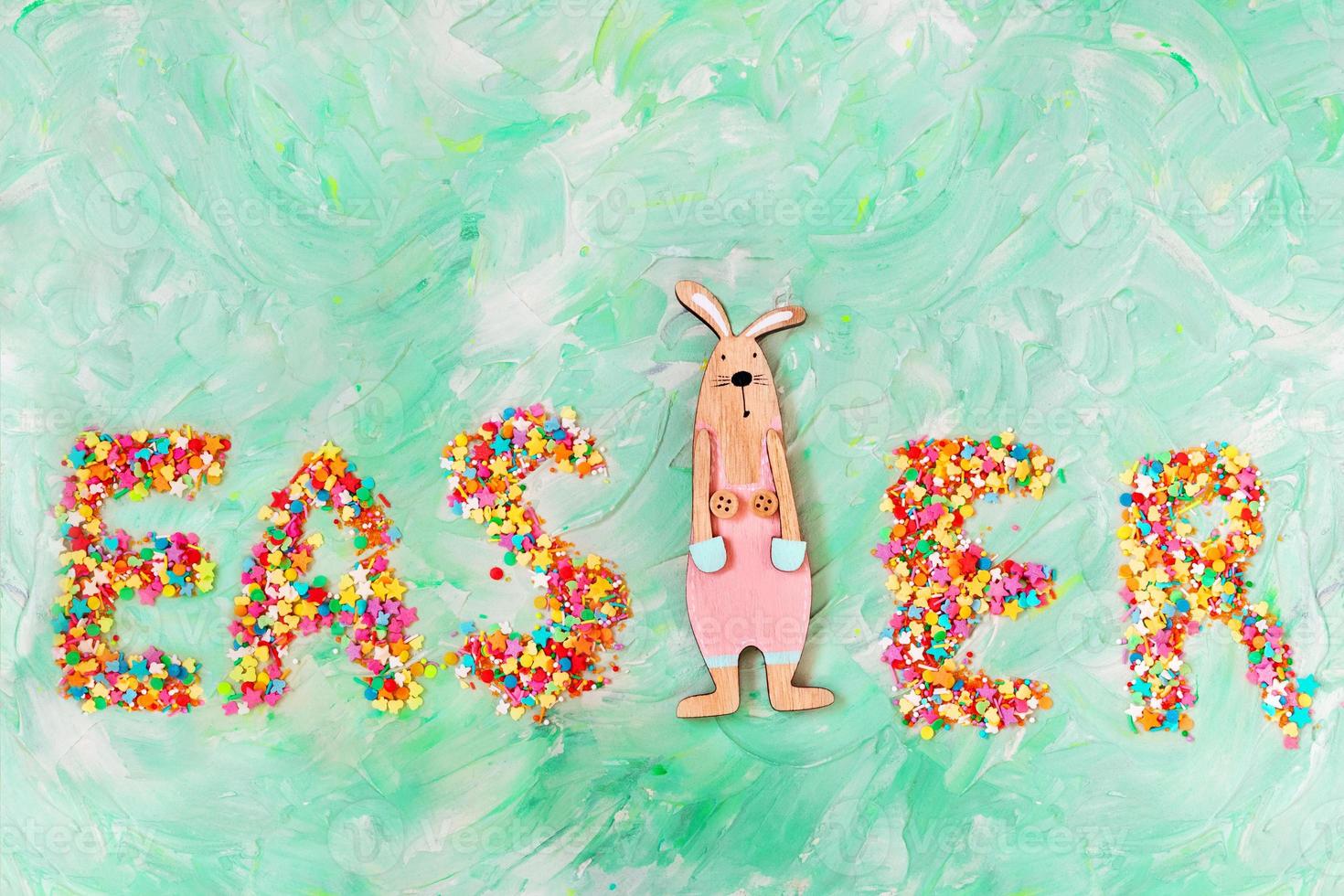 Text is lined with candy and rabbit on green background with brush strokes. Easter card. Copy space photo