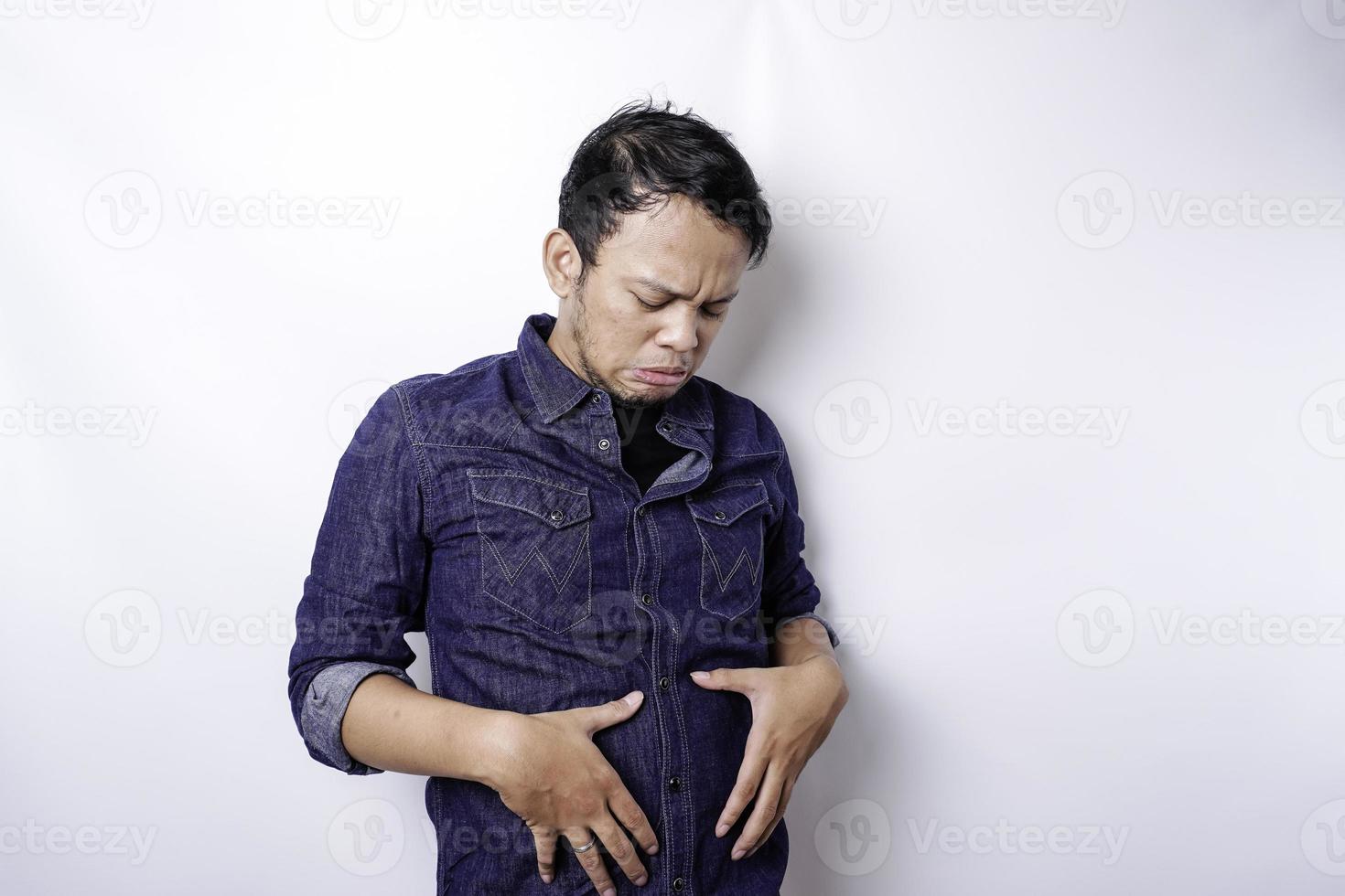 A portrait of insecure Asian fat man is holding the fat on his belly photo